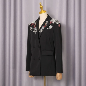 Detailansicht der bunten Paillettenstickerei und Strasssteine auf dem schwarzen Blazer-Revers