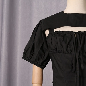 Detail of black puff sleeve top featuring chest hollow-out design and lace-up pleats