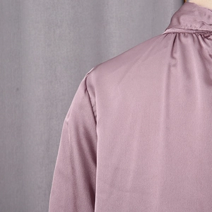 Détail d'une chemise en satin mauve montrant la couture de l'épaule et la soie fine