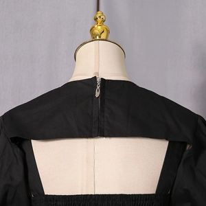 Detailed back view showing the silver zipper and horizontal cutout design on black top