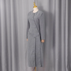 Detail shot of asymmetric button design on a grey wool blend long coat for women