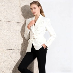 Detailed view of white double-breasted blazer featuring pearl buttons and a waist belt