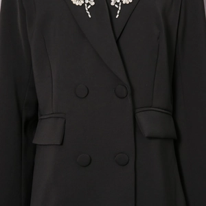 Detail eines schwarzen Doppelreiher-Blazers mit Strass-Kragen und flachen Pattentaschen