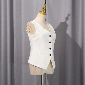 Detail of white V-neck tailored vest with black buttons and sharp asymmetrical hemline