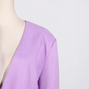 Detail of lavender V-neck blazer showing fine fabric texture and shoulder stitching craftsmanship