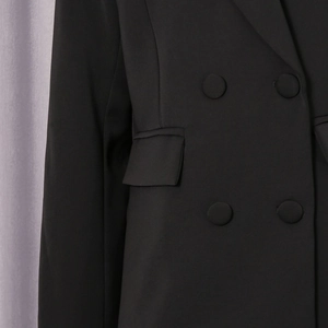 Detail eines schwarzen zweireihigen Blazers mit Stoffknöpfen und Klappentasche