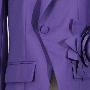 Close-up of a purple blazer featuring a 3D fabric flower and matching cloth button