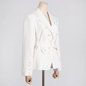 Detail of white double-breasted blazer showing marble buttons and waist belt texture