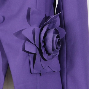 Detail of 3D fabric flower on purple blazer showing elegant texture and craftsmanship