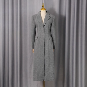 Detailed view of grey wool coat featuring classic notched lapels and side flap pockets