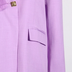 Macro detail of lavender blazer featuring gold relief buttons and woven fabric texture