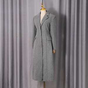 Detail of grey wool blend coat featuring classic notch lapels and pocket flap textures