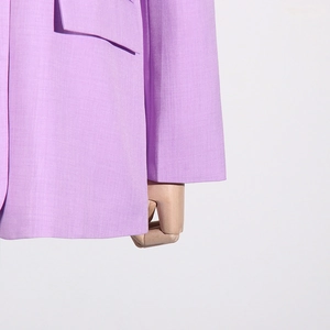 Detail of lavender blazer showing fine fabric texture and flap pocket construction