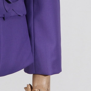 Detail of purple blazer sleeve with 3D floral applique and twill fabric texture