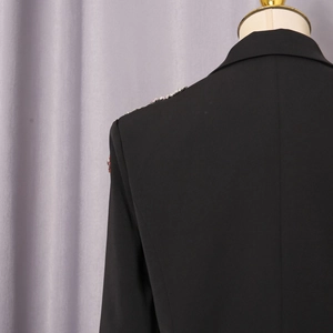 Detailaufnahme eines schwarzen Blazers mit bunten Strass-Verzierungen an Schulter und Rücken