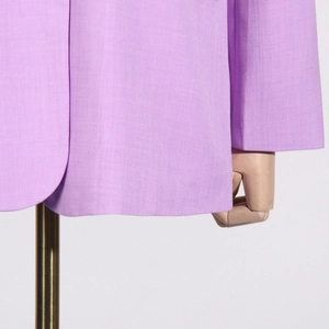 Detailed macro view of lavender textured blazer fabric with precise hem and cuff sewing