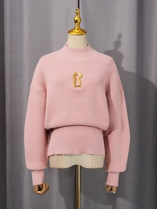 Pink oversized knit sweater featuring lantern sleeves and signature gold keyhole detail
