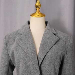 Close-up of a gray wool coat featuring a notch lapel and fine textured fabric detail