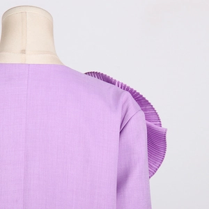 Detail of lavender blazer shoulder featuring structured accordion pleated floral trim detail