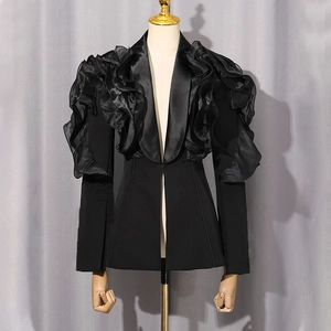 Detail of ruffled organza layers on black tailored blazer shoulder with slit cuff design
