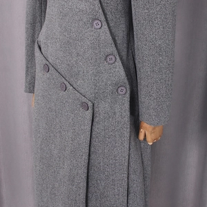Detail of grey wool coat featuring asymmetrical slanted placket and six-button closure