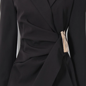 Detail of waist wrap design with light gold metal buckle on a black blazer jacket