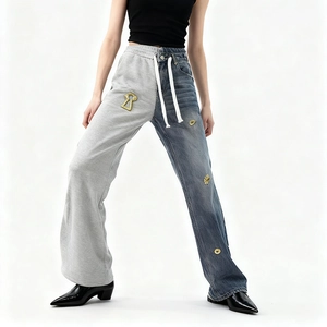 Detail of contrast patchwork jeans with blue denim and grey knit fabric panels