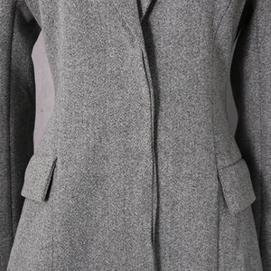Detail showing high-quality gray wool blend texture and waist tailoring of this coat