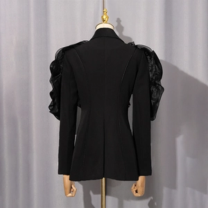 Detail of the back waist tailoring and layered ruffle puff sleeves on a black blazer