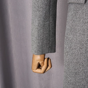 Detailed macro view of the grey wool blend fabric texture on the loose casual coat