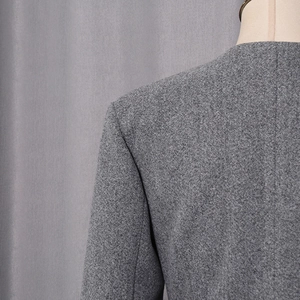 Detailed macro view of gray wool blend fabric texture and professional shoulder stitching