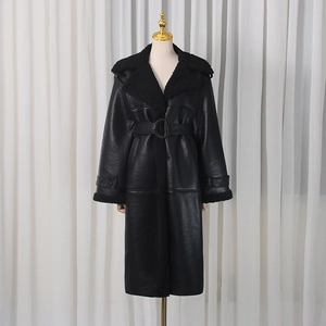 Close-up of black leather trench coat featuring plush faux fur trim and waist belt details