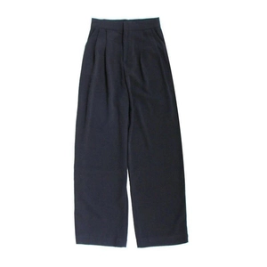Makro-Detail des hochtaillierten Plissee-Designs an dunkelblauen weiten Hosen aus Webstoff