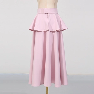 Détail d'une élégante jupe rose à volants étagés avec design double couche et drapé long