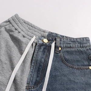 Detail of grey jersey and blue denim patchwork jeans with golden metal buttons