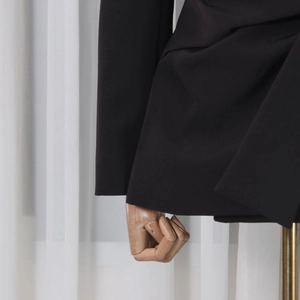 Close-up of sleek black blazer sleeve and hemline with premium tailored stitching