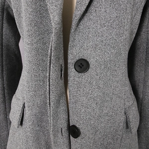 Detailed macro view of grey wool coat texture, notch lapel and classic black buttons