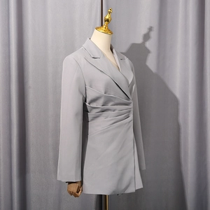 Details des grauen Blazers mit eleganter Faltentaille und matter Textur