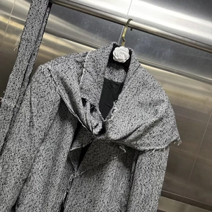 Detail of French vintage tweed jacket featuring chic herringbone weave and fringe scarf