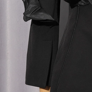 Detailed view of women black suit jacket featuring unique slit cuffs and sheer tulle inserts