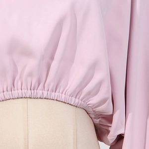 Détail de la taille élastique à volants sur un haut en mousseline rose clair de style français