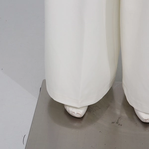 Detail view showing smooth drape and hem of elegant white wide-leg trousers