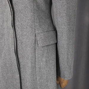 Detail view of high-quality grey wool fabric texture and pocket stitching on loose coat