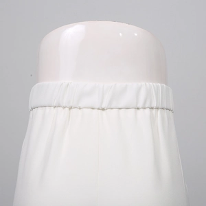 Detail of the elastic waistband on white trousers with fine stitching and soft fabric