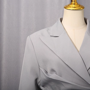 Detailaufnahme des grauen Blazers mit Reverskragen und feiner gewebter Textur