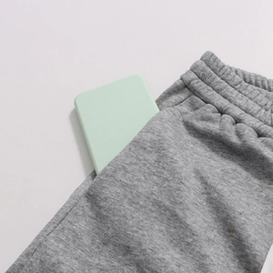 Detail of grey joggers featuring elastic waistband and large side pocket with phone inside