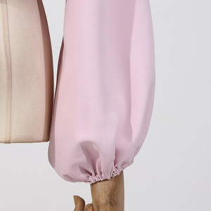 Détail des manches lanternes roses avec poignets élastiques sur un chemisier style français