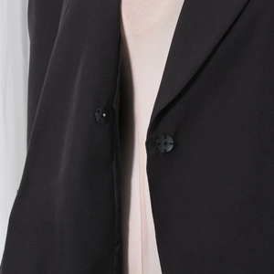 Close-up of precise stitching and black buttons on a tailored formal blazer lapel