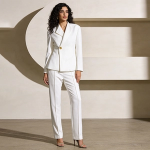 Detailed view of women's white blazer set with gold button closure and tailored pants
