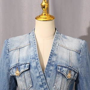 Detail of light blue denim jacket with V-neckline and ornate gold metal buttons